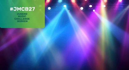 Bunte Bühnenbeleuchtung mit farbigen Spotlights in Blau, Violett, Pink und Grün, die durch einen dunklen Veranstaltungsraum strahlen. Oben links befindet sich ein grünes Feld mit dem Text „#JMCB27 Jugend Music Challenge Borken“.